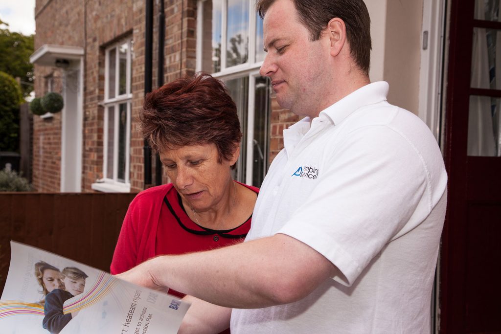 Plumbing engineer with a client outside the front door